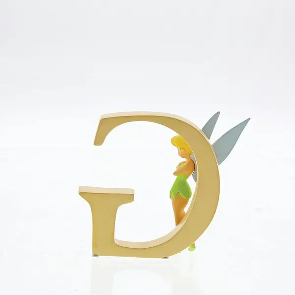 Een Tinkerbell-figuurtje dat tegen een gouden letter