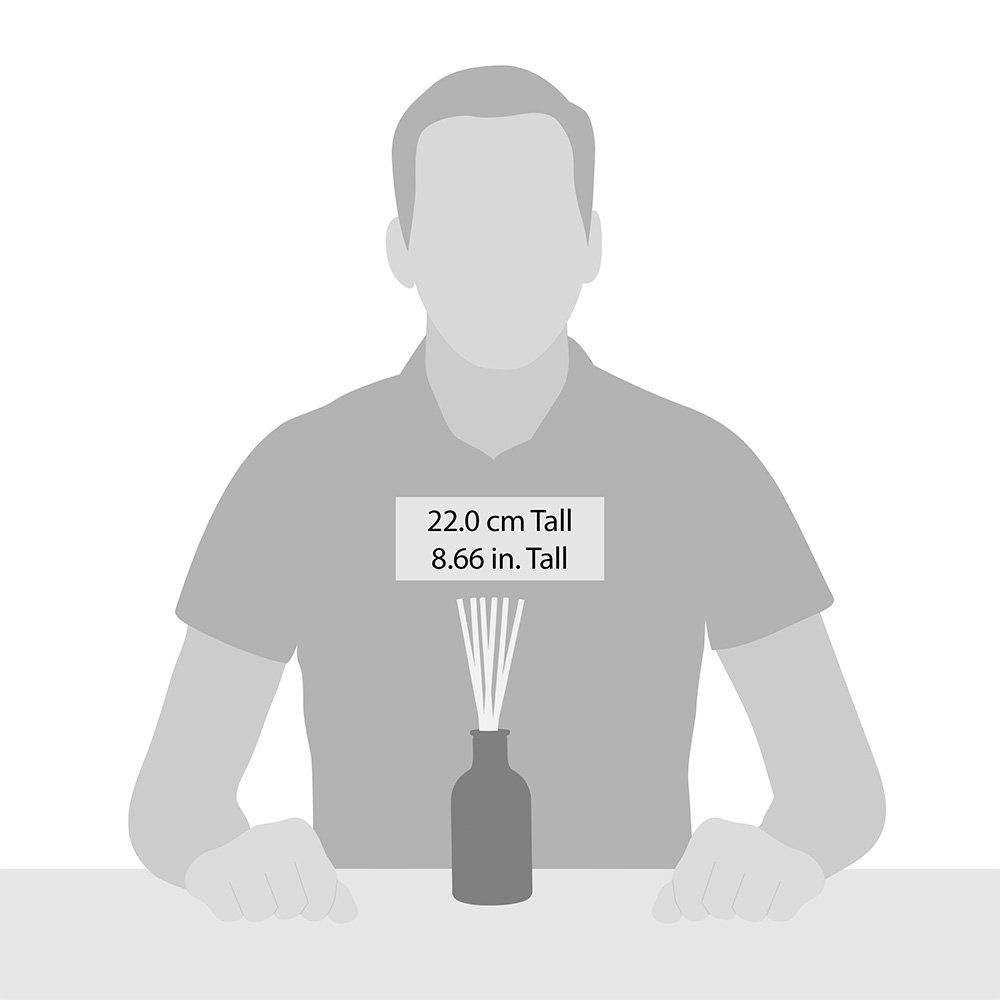 Een man zit aan een tafel met een flesje geurstokjes.