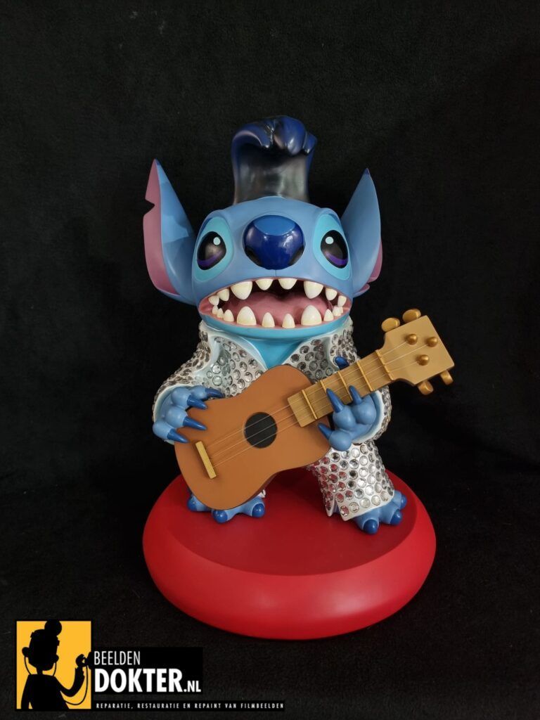 Een beeldje van stitch houdt een gitaar vast