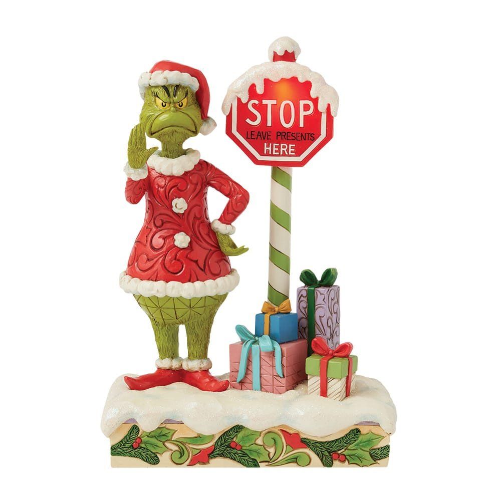 Een beeldje van een Grinch die naast een stopbord staat