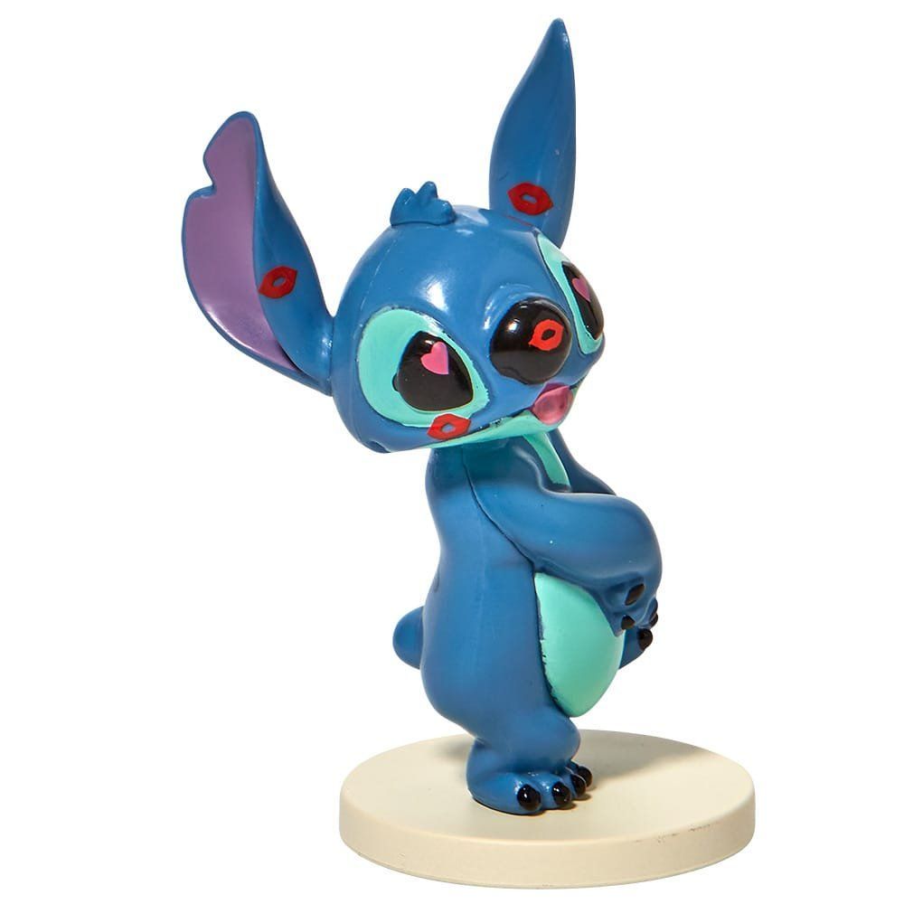 Een beeldje van Stitch van Disney, staand op een witte voet.