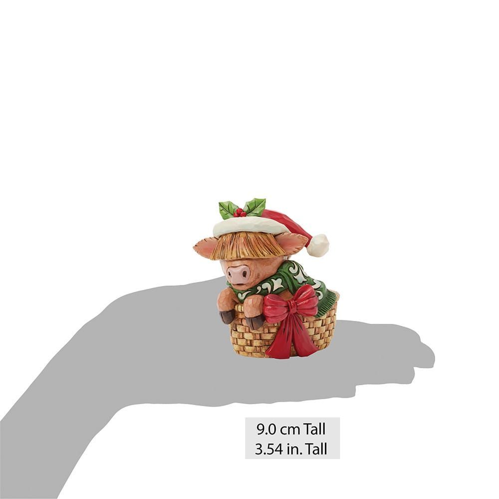 Een varken met een kerstmuts op zit in een mand.