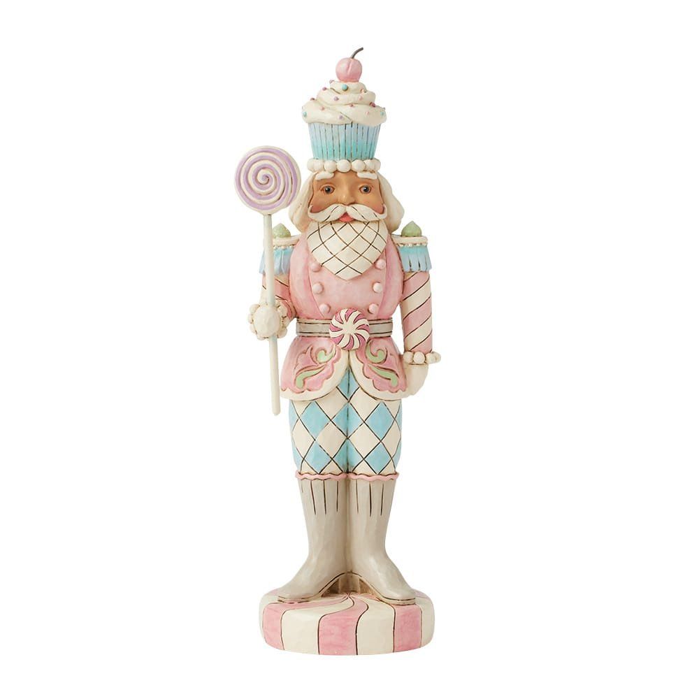 Een notenkrakerfiguur met een cupcake op zijn hoofd en een lolly.