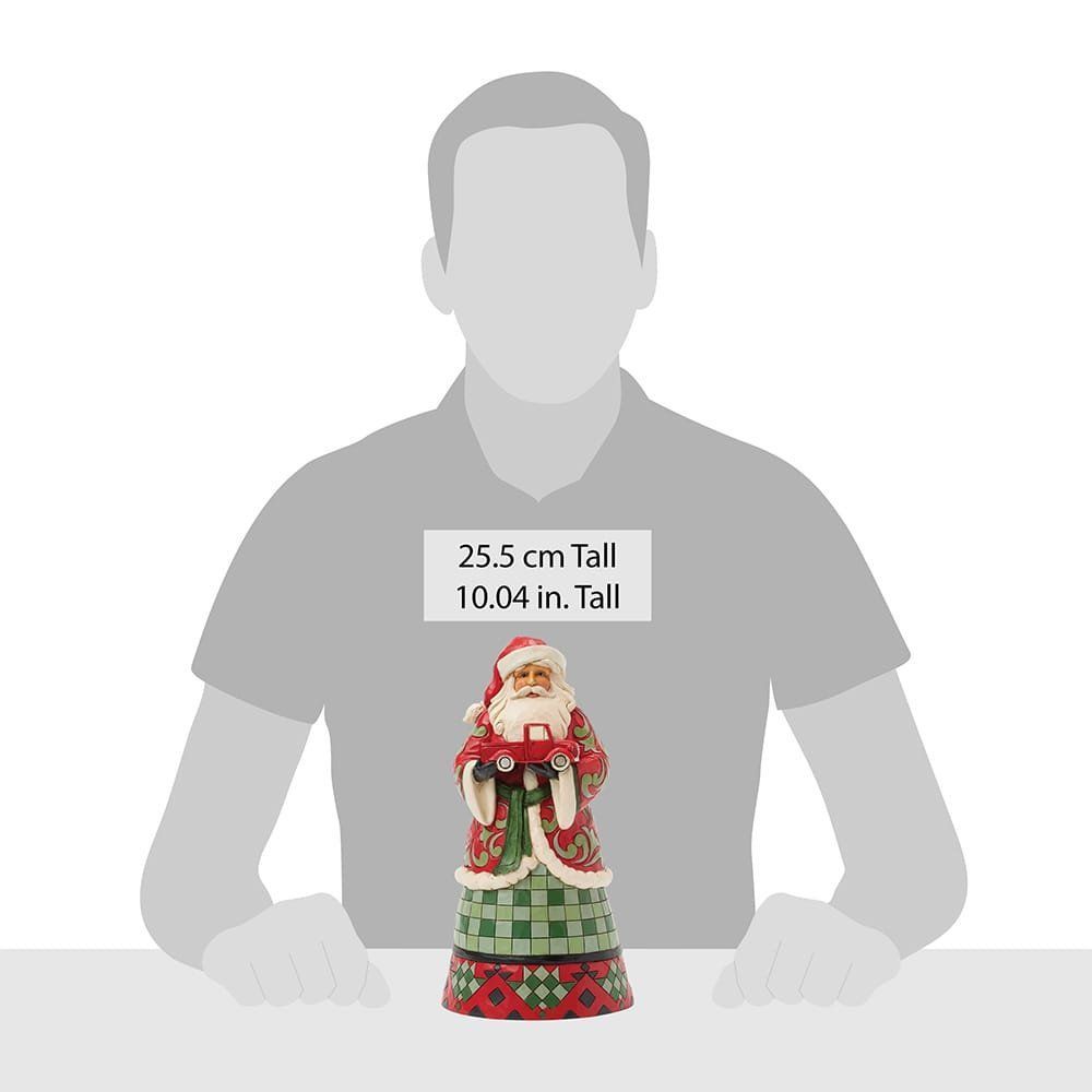 Een beeldje van de Kerstman die een rode vrachtwagen vasthoudt.