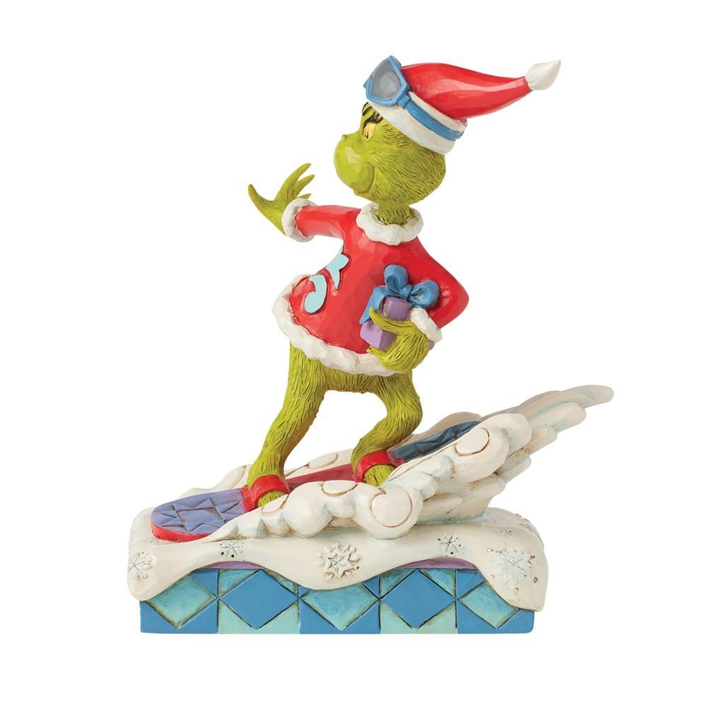 Een beeldje van de Grinch rijdt op een snowboard.