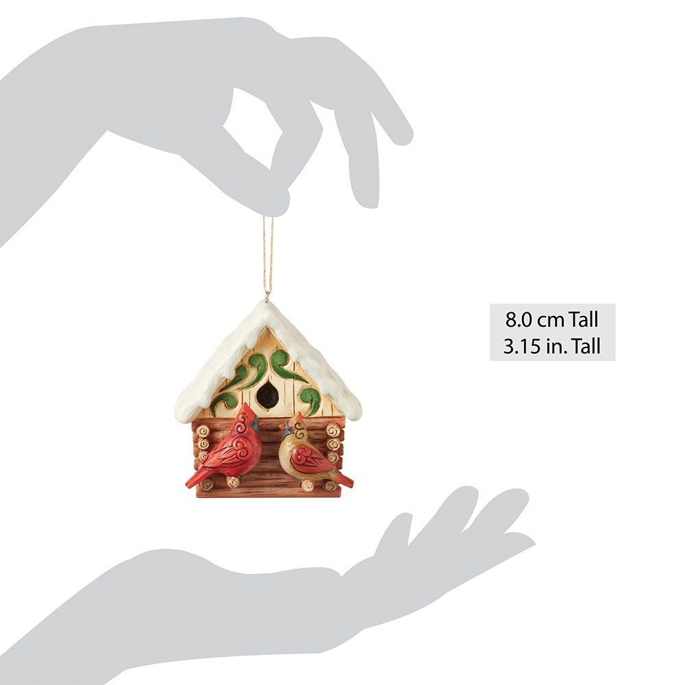 Twee kardinalen zitten in een vogelhuisje.