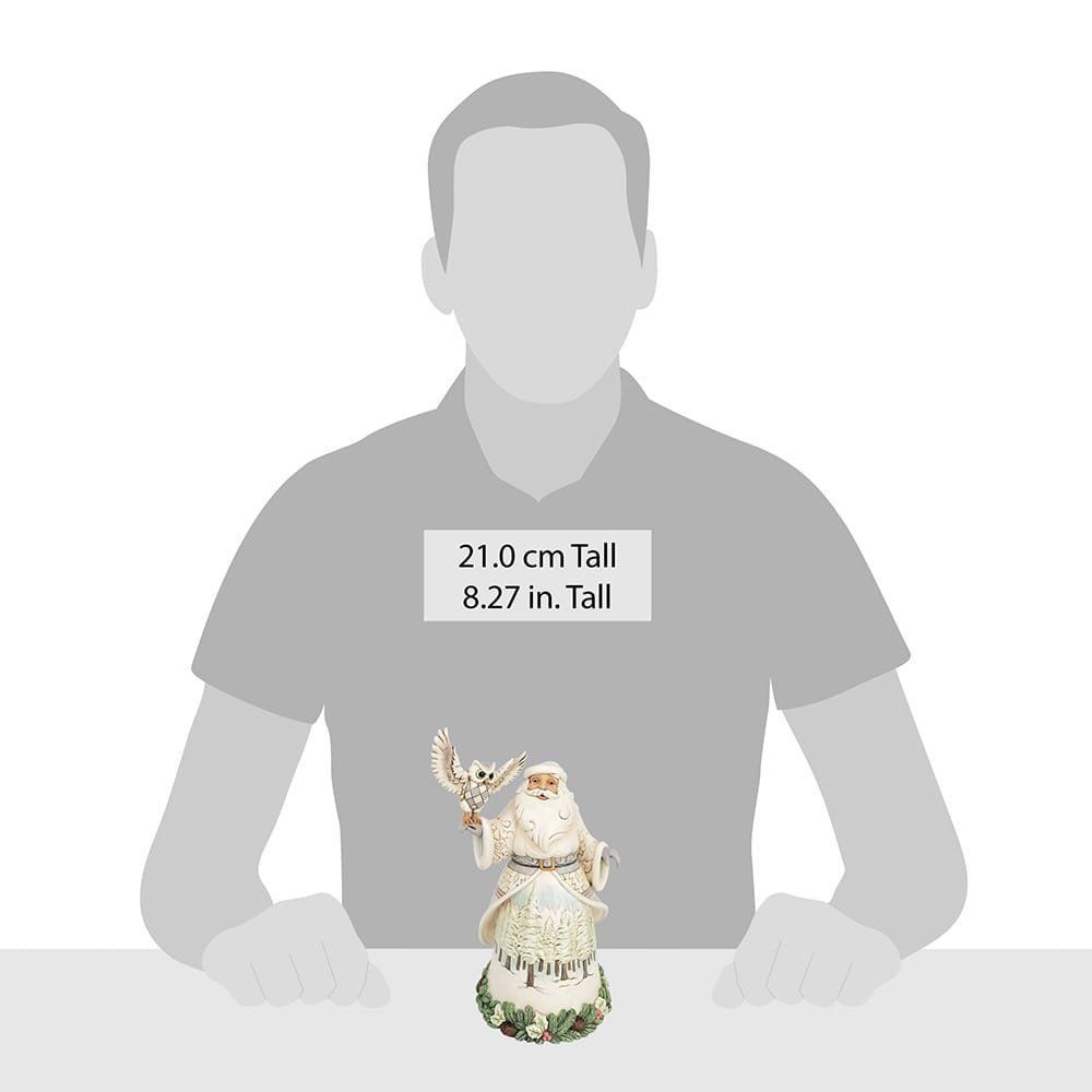 Een beeldje van de kerstman die een uil in zijn hand houdt