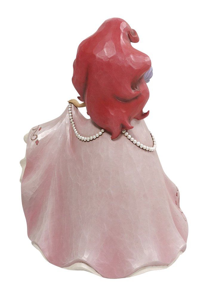 Een beeldje van een prinses in een roze jurk die een dienblad met bloemen vasthoudt.