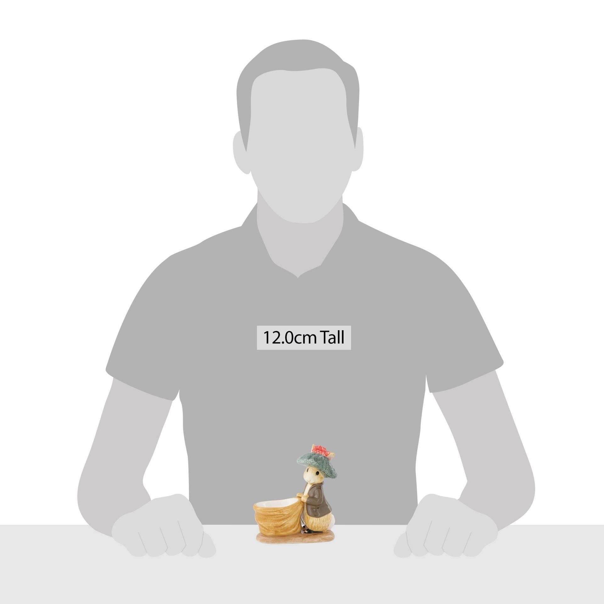 Een man zit aan een tafel met daarop een beeld van een konijn.