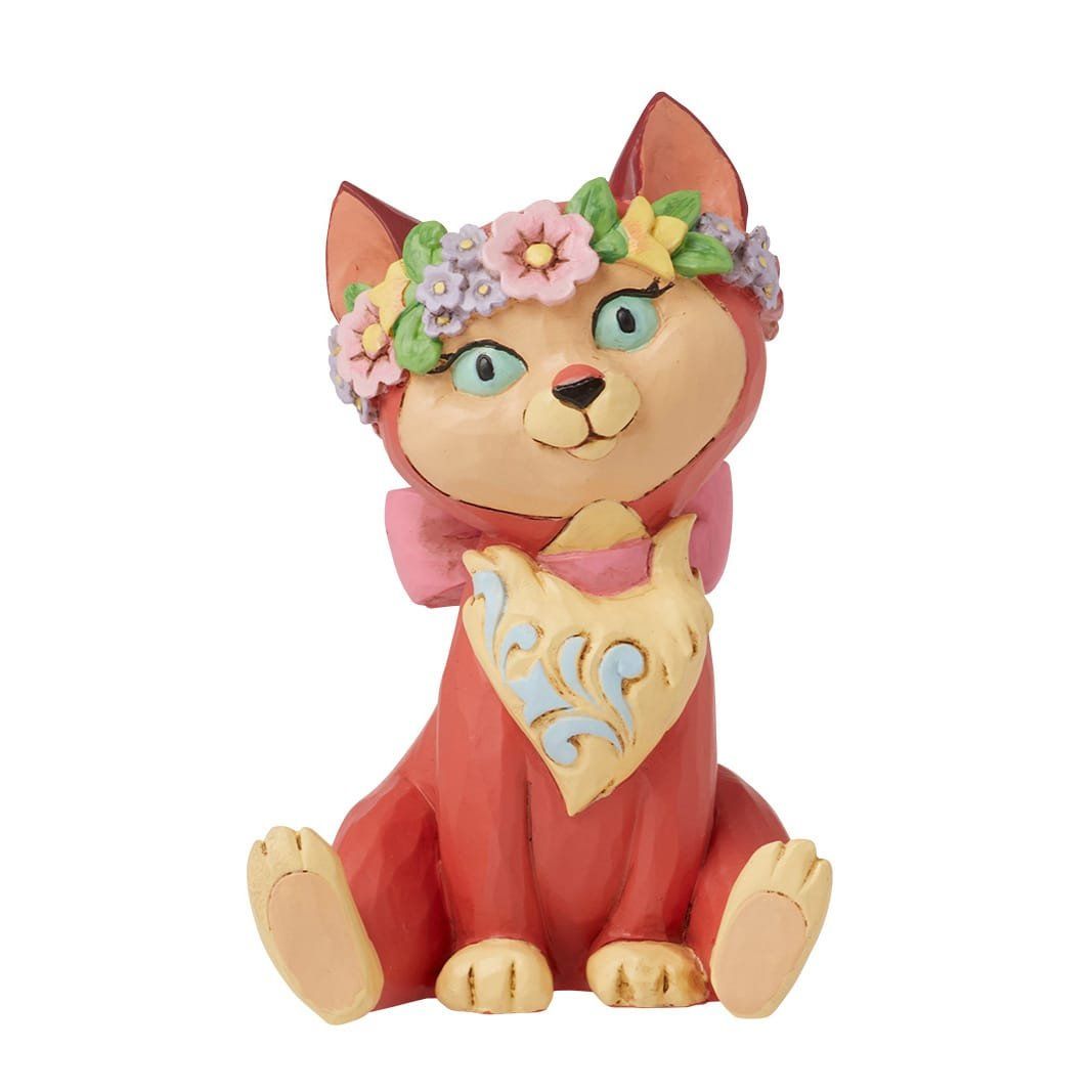 Een beeldje van een kat met een bloemenkroon op zijn kop.