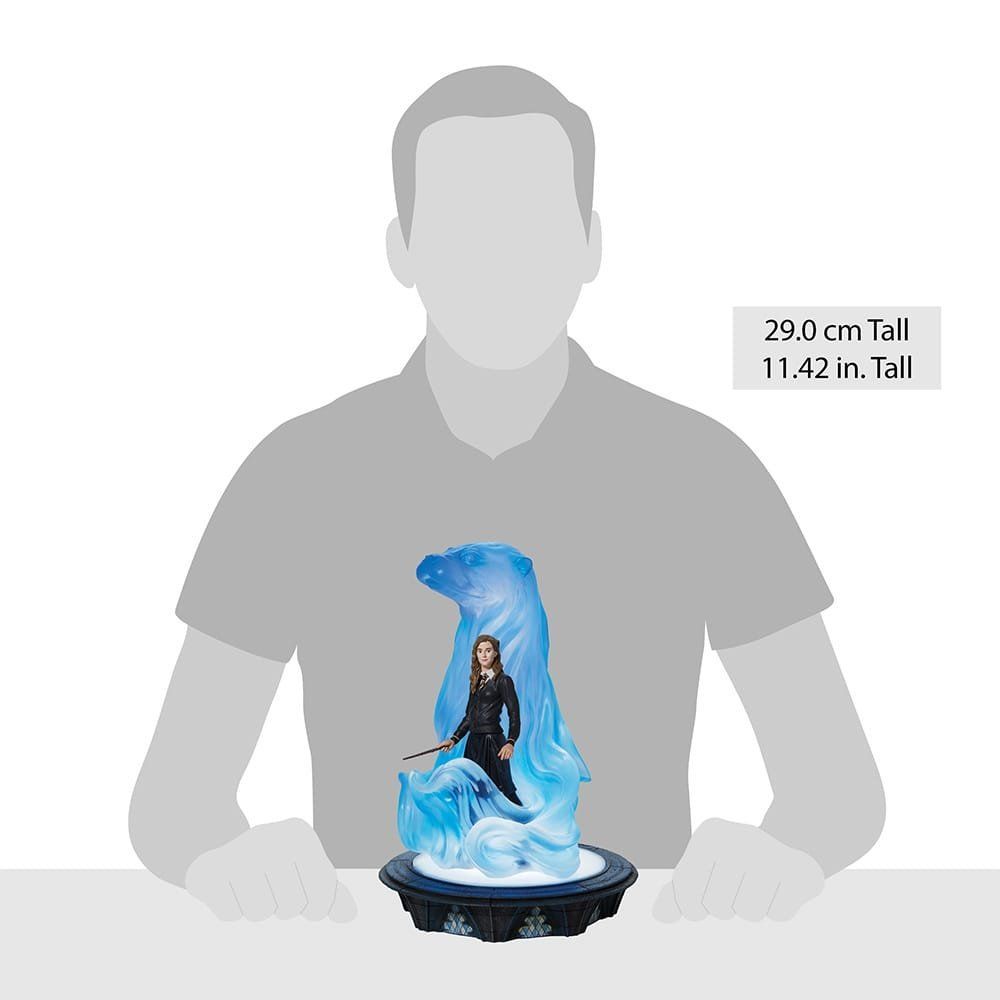 Een man zit aan een tafel en houdt een beeld van een vrouw vast.