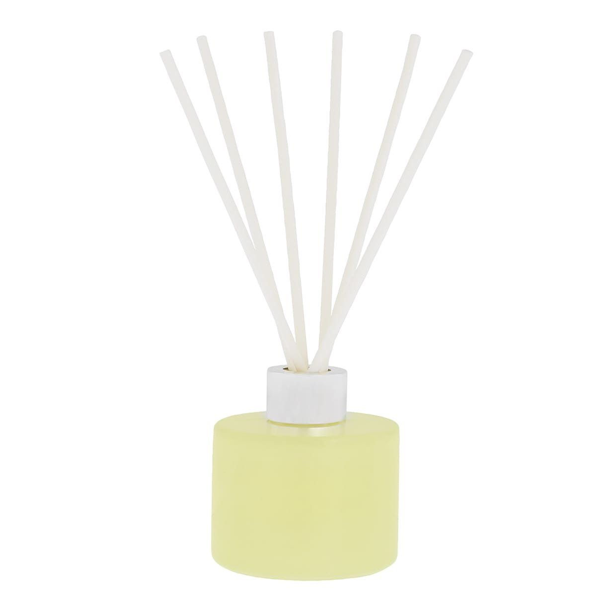 Een flesje geurstokjes met stokjes erin op een witte achtergrond.