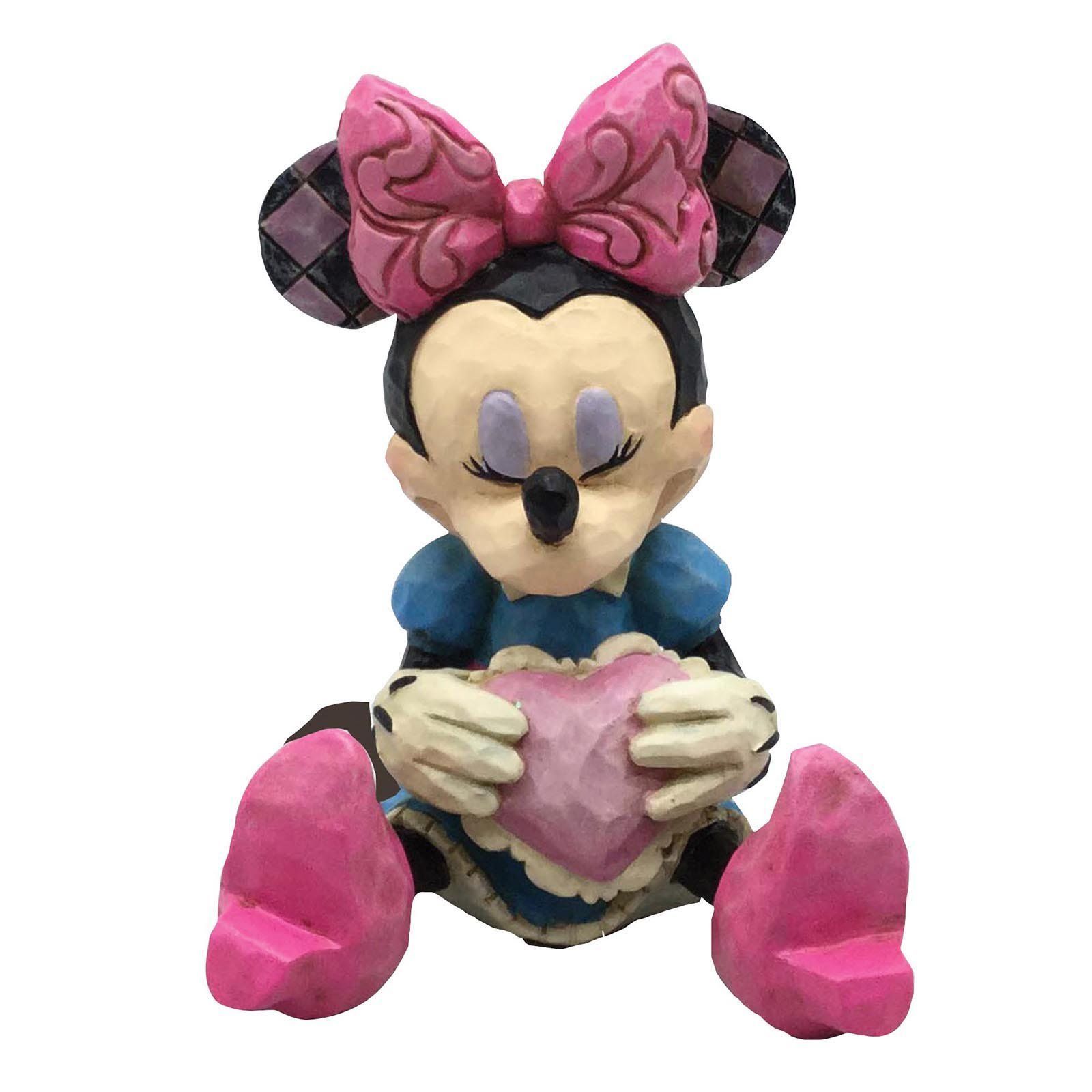 Een beeldje van Minnie Mouse die een roze hart vasthoudt.