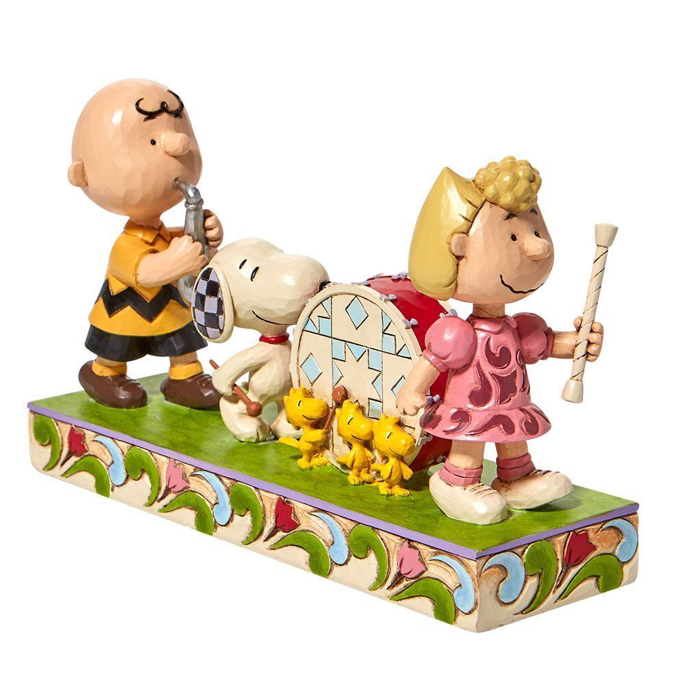 Een beeldje van Snoopy, Charlie Brown en Sally die naast elkaar staan.