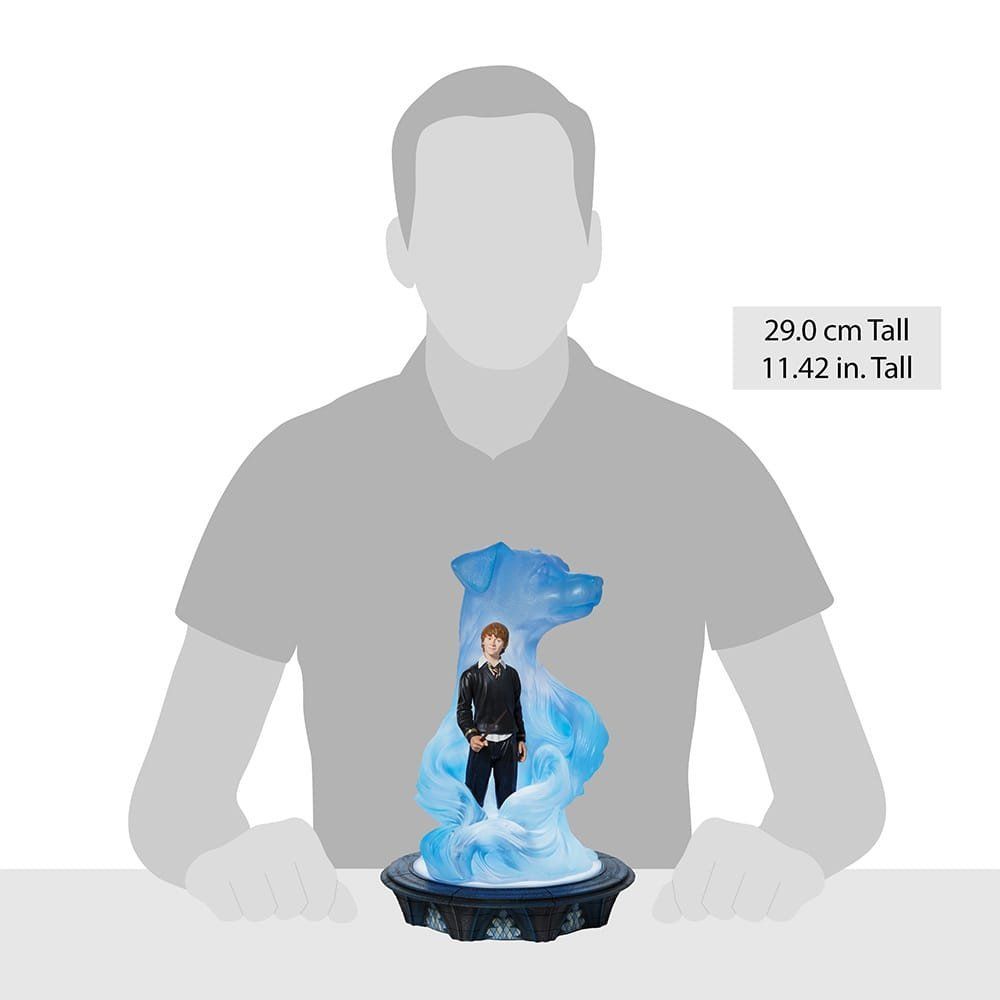 Een man zit aan een tafel met een standbeeld van een man voor hem.