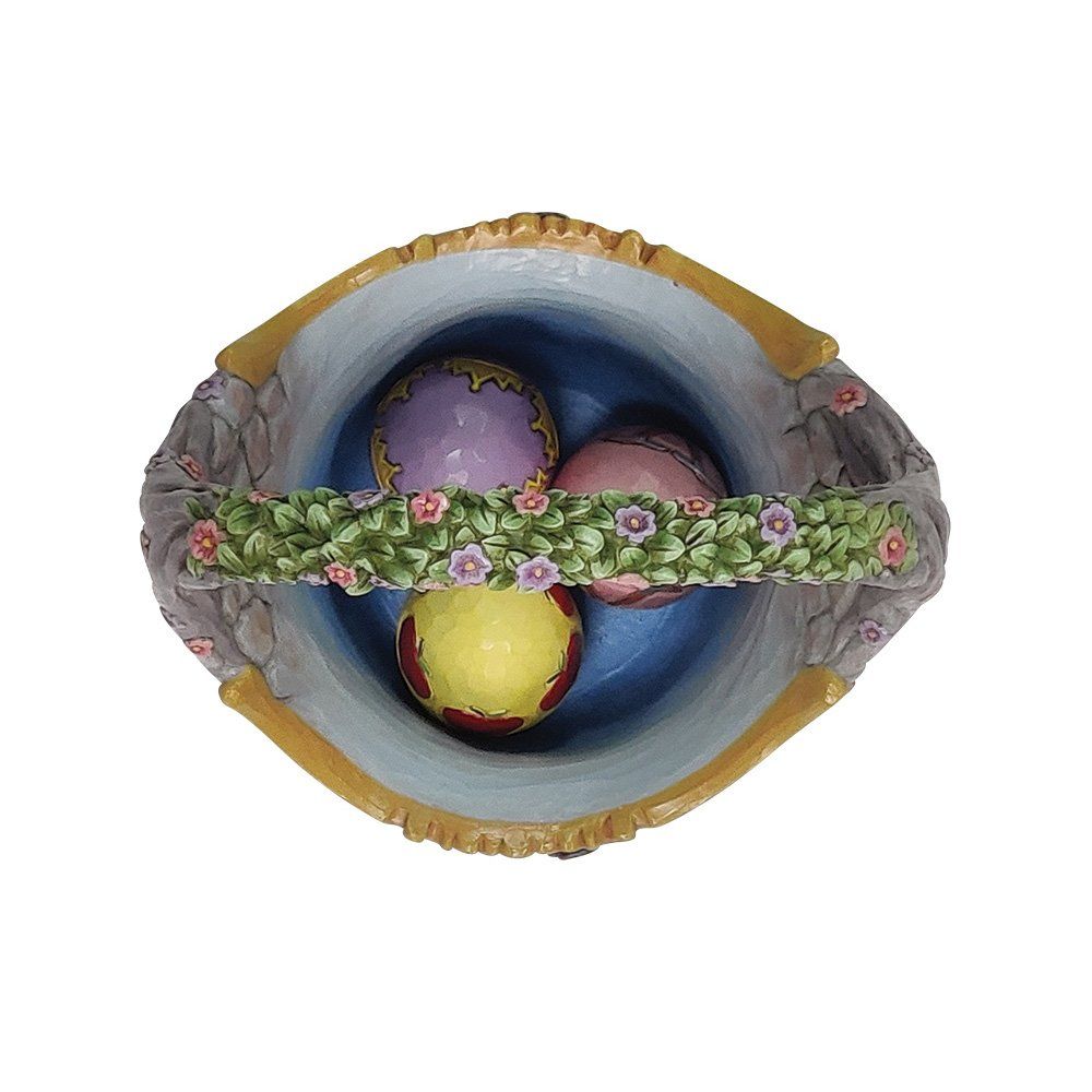 Drie paaseieren in een mandje met bloemen op het handvat