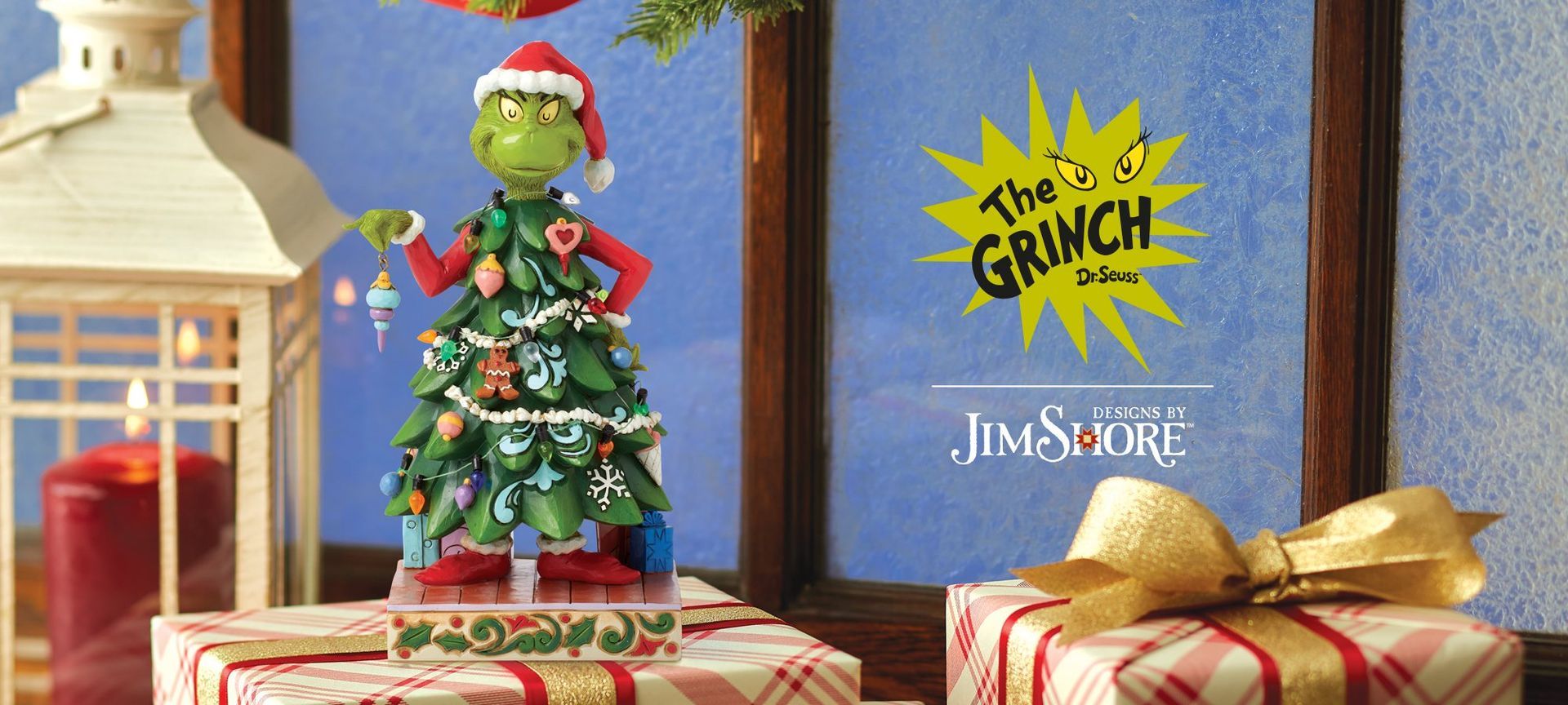 Een grinch-beeldje staat naast een kerstboom