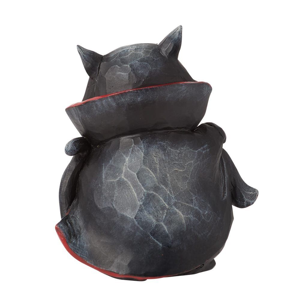 Een beeldje van een zwarte kat gekleed als vampier.