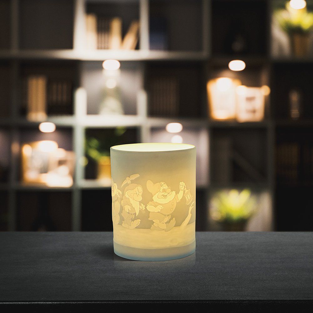 Een kaarsenhouder met een Mickey Mouse-ontwerp staat op een tafel