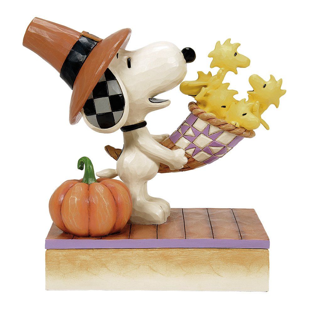 Een beeldje van Snoopy met een pelgrimshoed en een mand met Woodstock