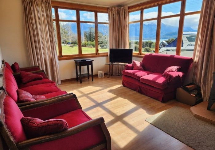 Living room with red couches, large windows, and a view of mountains.