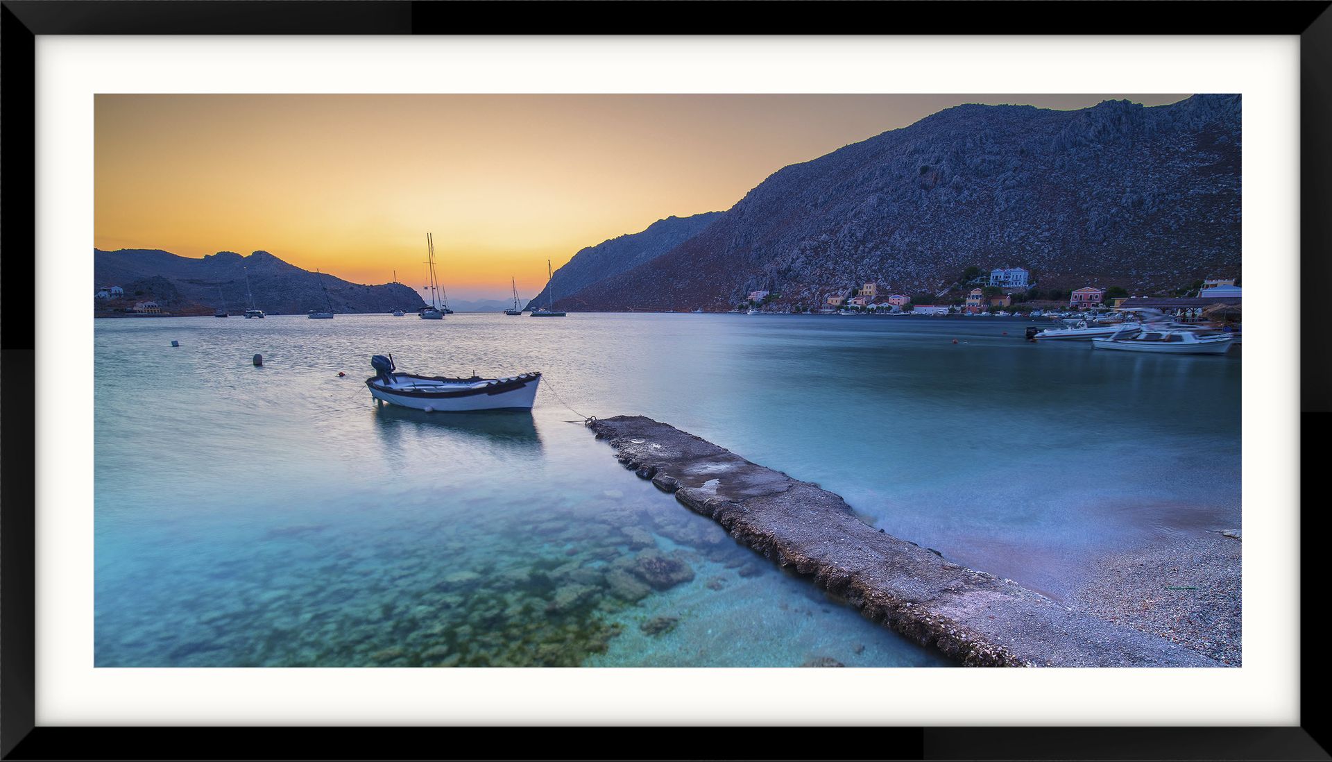 Greek landscape photography at Symi Island - a picture of a boat in the water with mountains in the background
