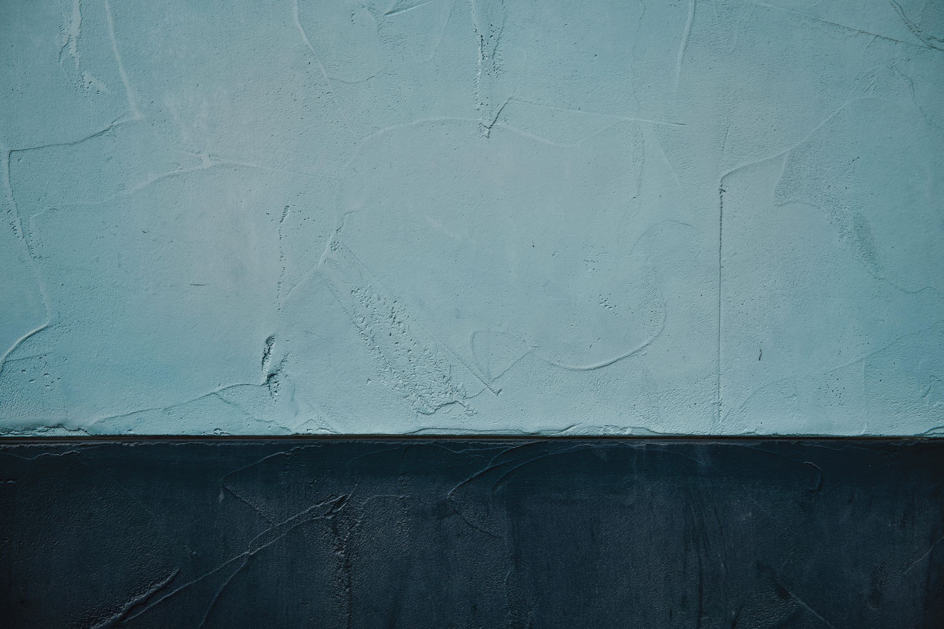 Two-toned wall: light blue upper half, dark blue lower half, textured, with a horizontal line dividing them.