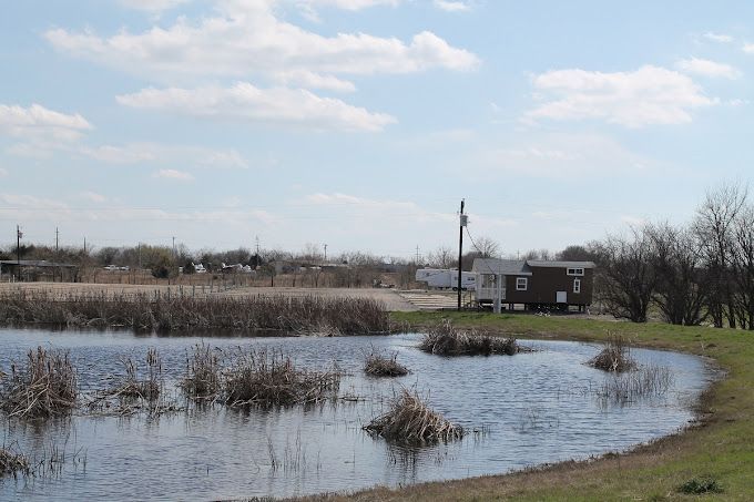 A small pond with a house in the background