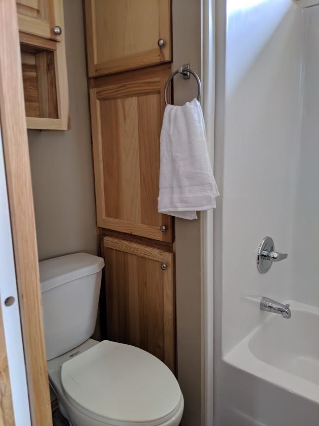 A bathroom with a toilet , sink and bathtub.