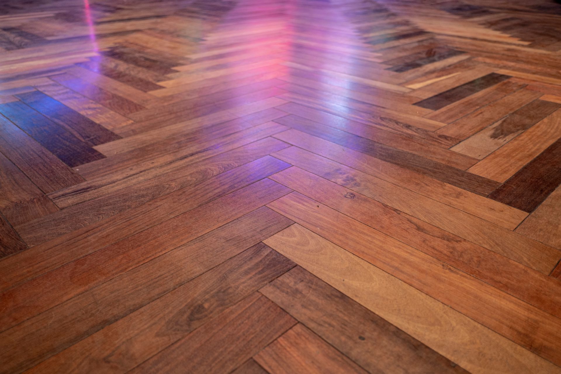 Wood floor with colorful light reflections.