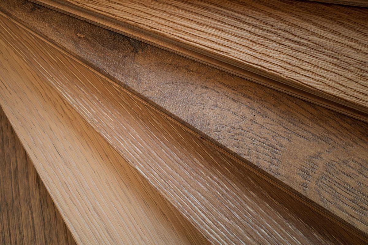 Close-up of angled wooden planks in varying shades of brown and tan, showcasing wood grain patterns.