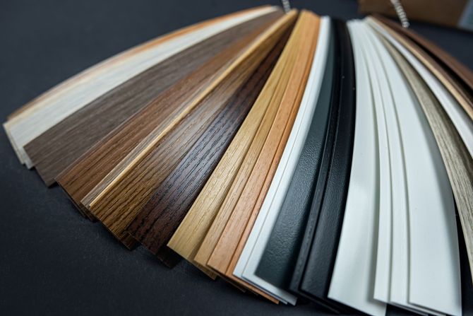 Color swatches of various wood trim finishes fanned out on a dark surface.