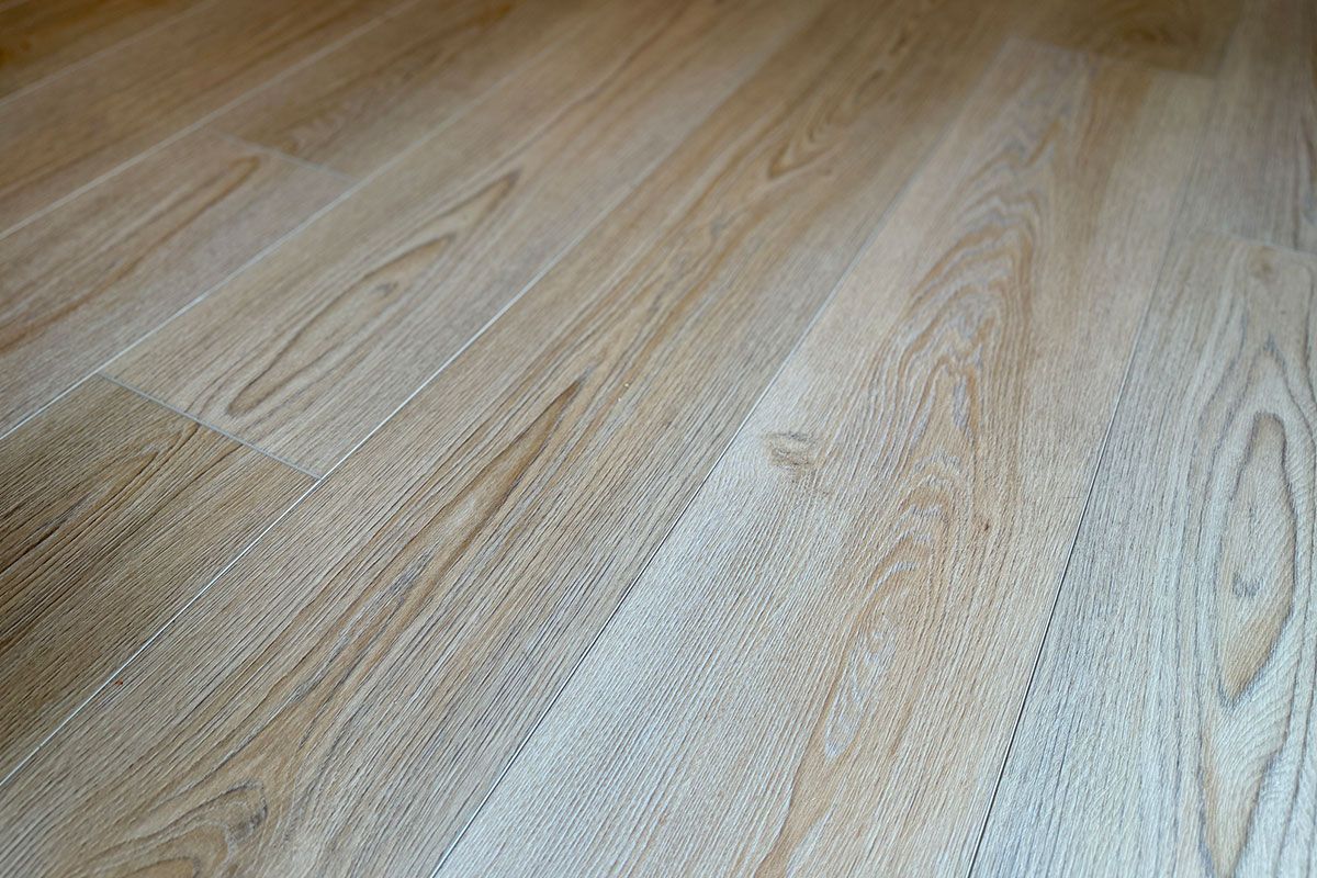 Light-colored wooden floor planks arranged diagonally, showing grain patterns.