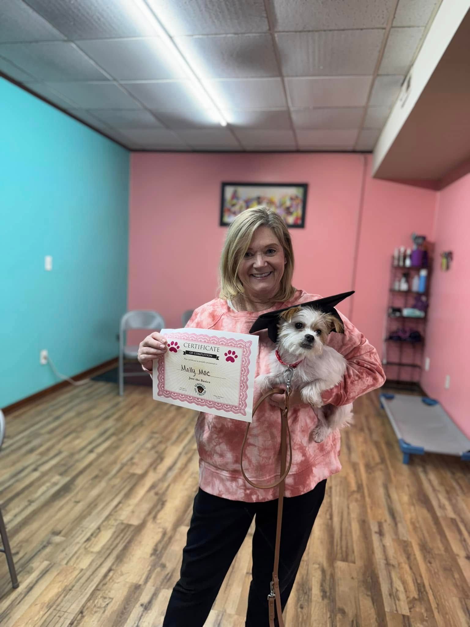 A woman is holding a dog in her arms and holding a certificate.
