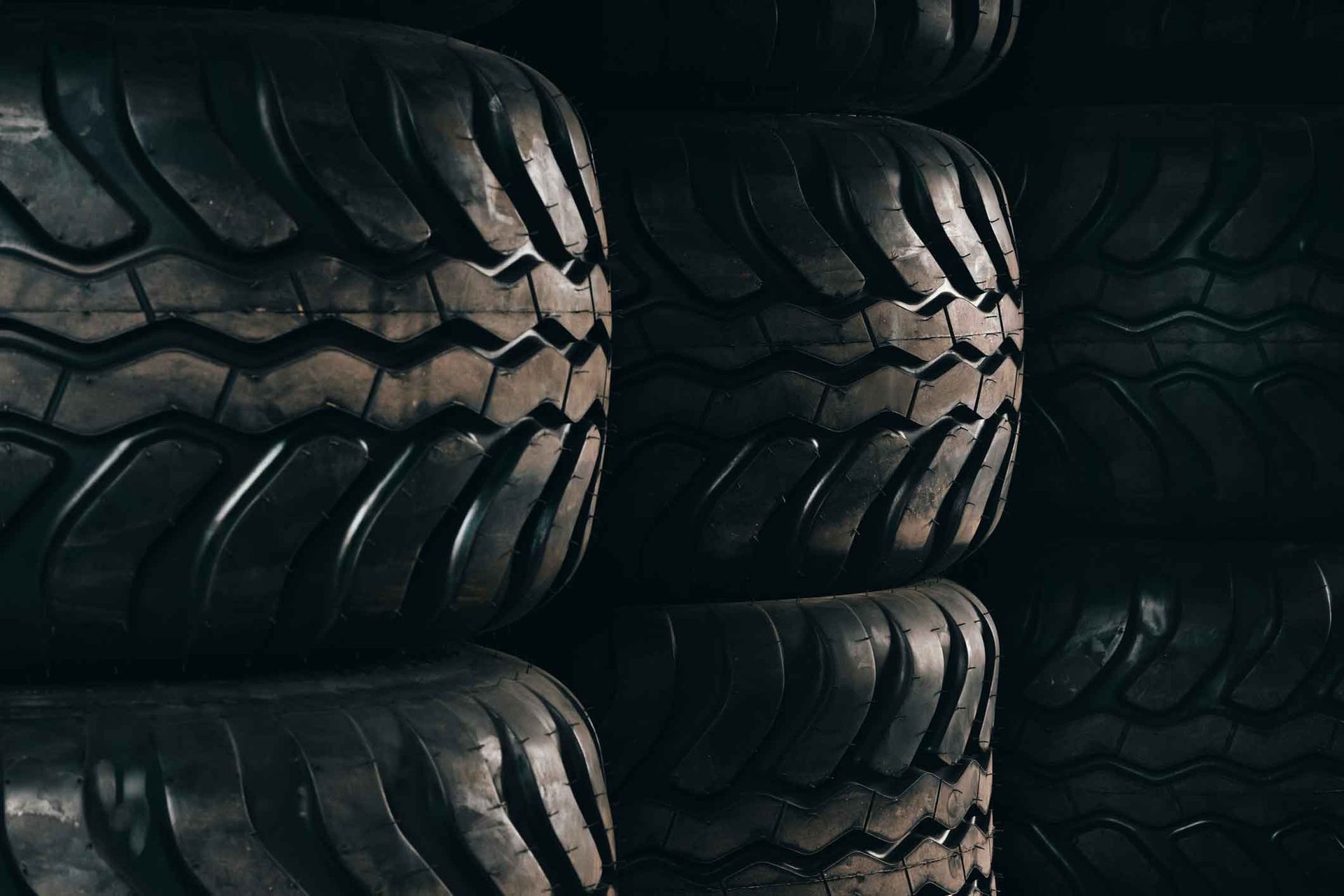 A pile of tires are stacked on top of each other in a dark room.
