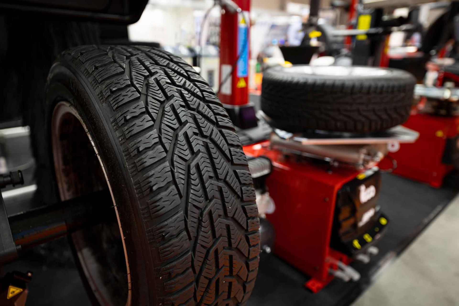 A close up of a tire on a machine in a garage.