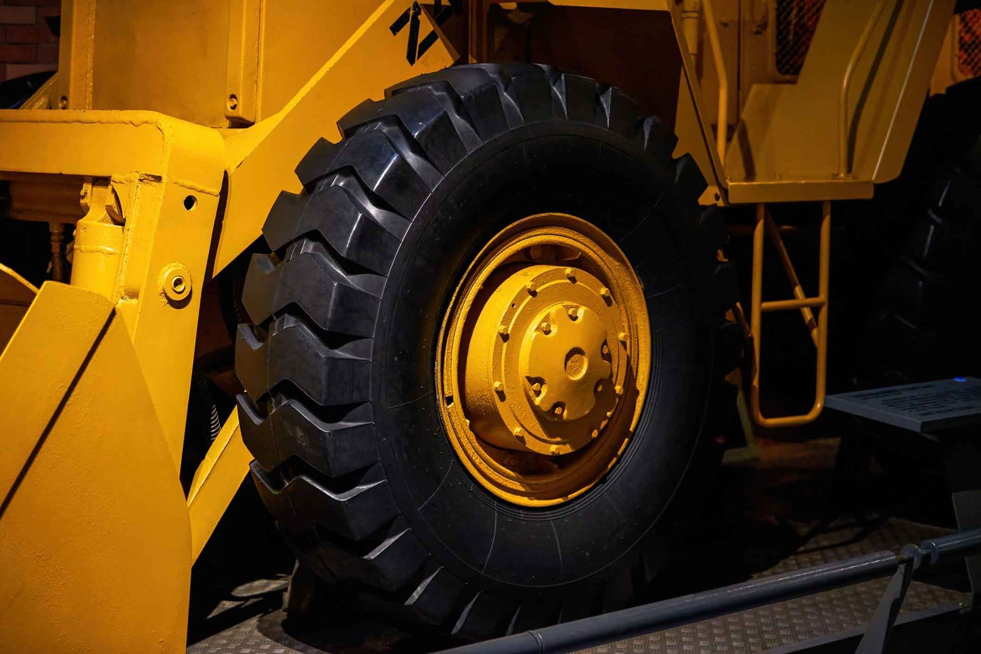 A close up of a yellow bulldozer 's tire