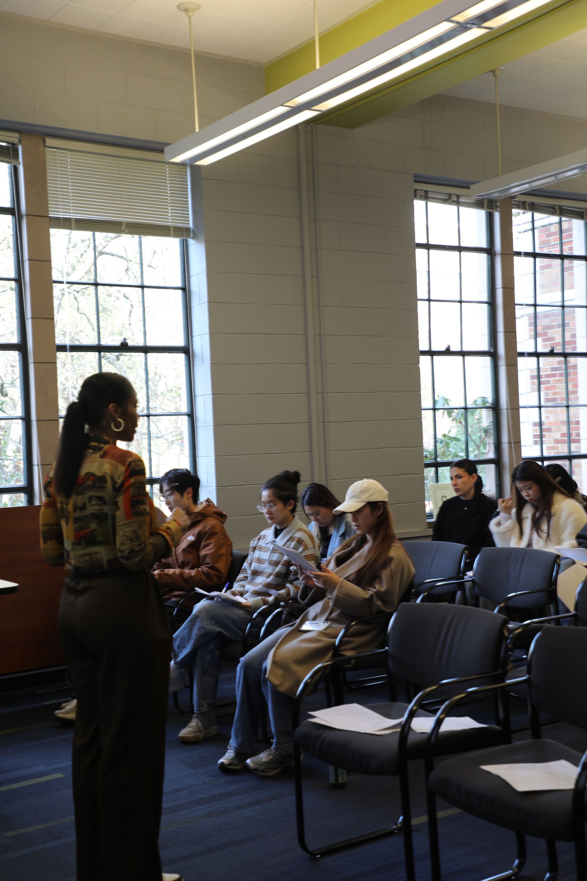 Group of people collaborating around a table. A person is working on a laptop while others are talking.