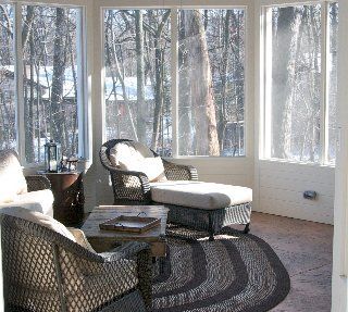 A living room with a lot of windows and chairs
