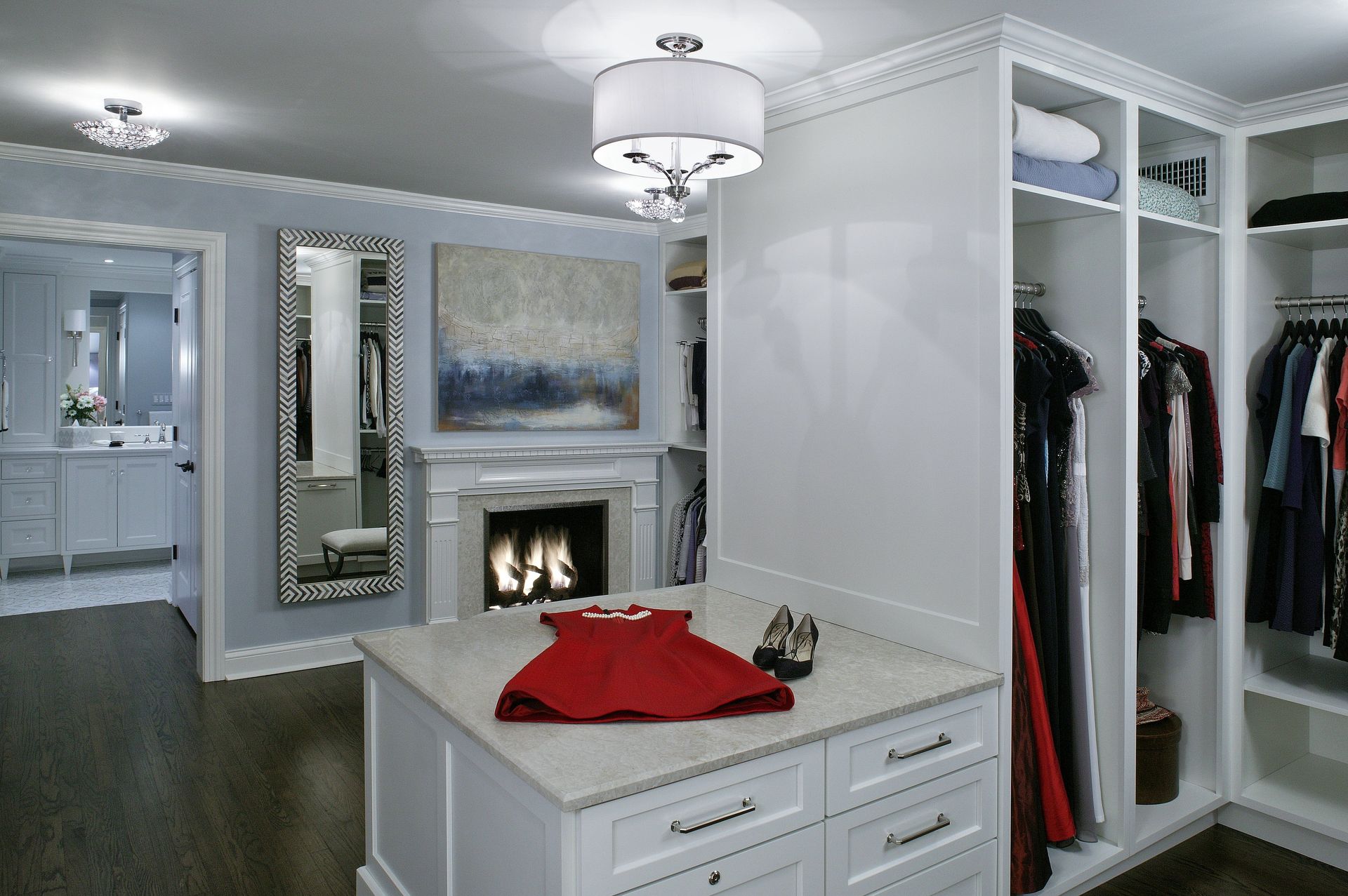 A walk in closet with a red dress on the island