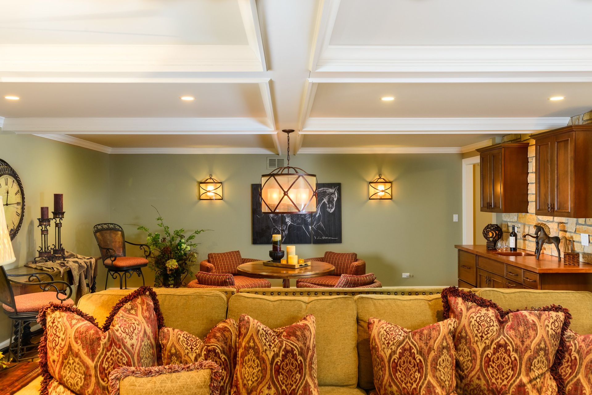 A living room with a couch , chairs , a table and a chandelier.