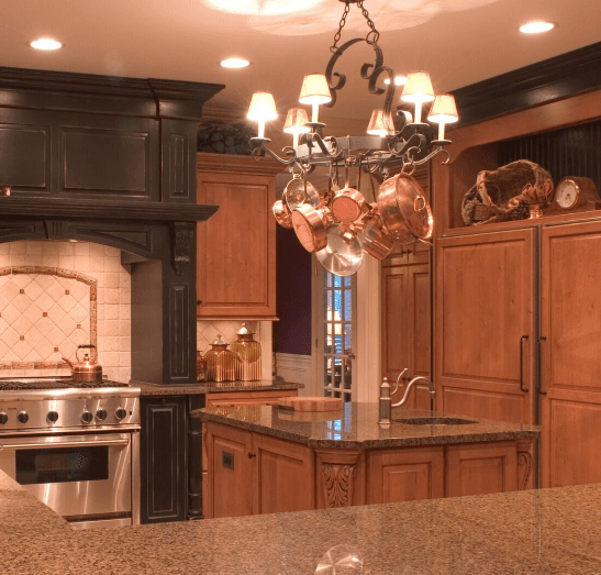 A kitchen with copper pots and pans hanging from the ceiling