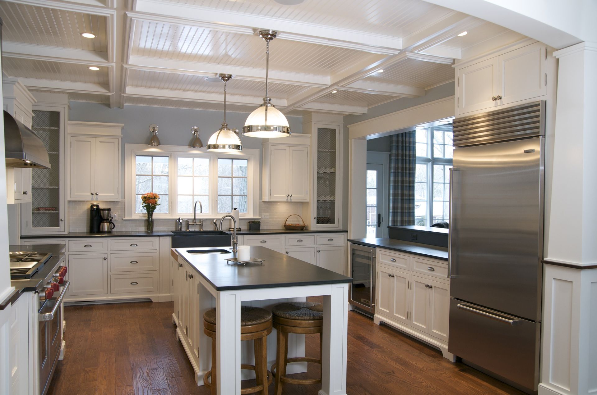 A large kitchen with white cabinets and stainless steel appliances