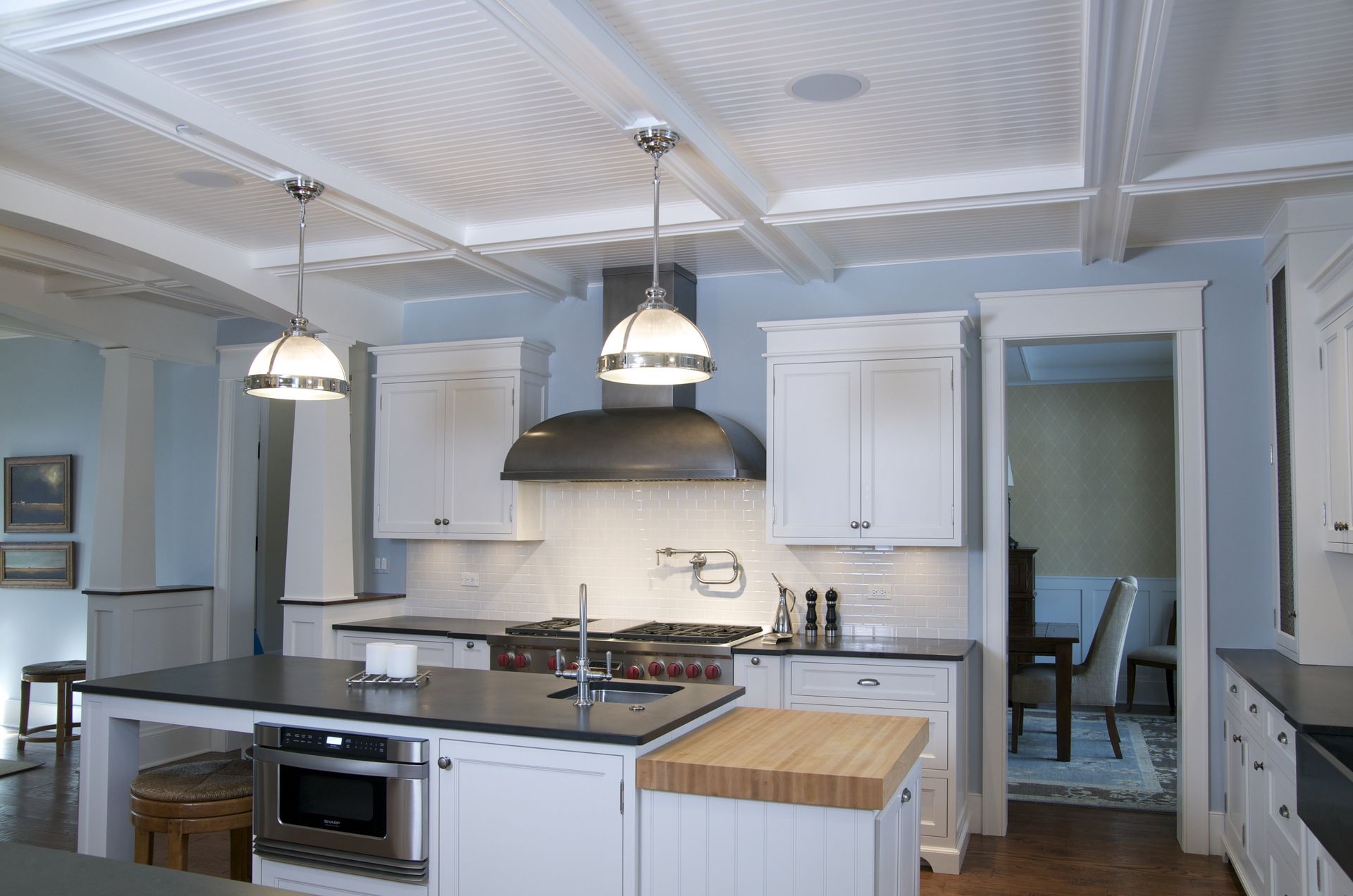 A kitchen with white cabinets and black counter tops