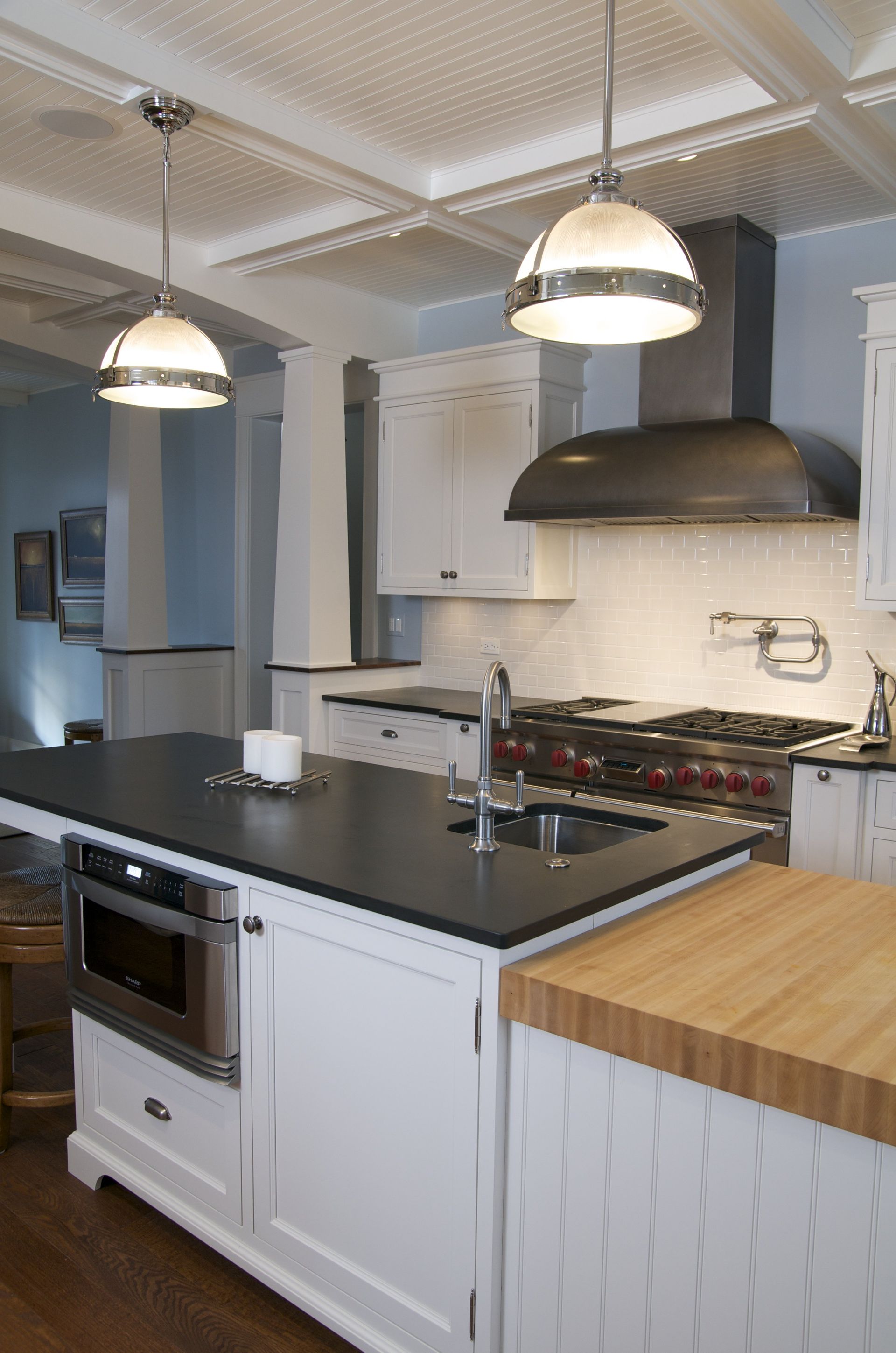 A kitchen with white cabinets and black counter tops