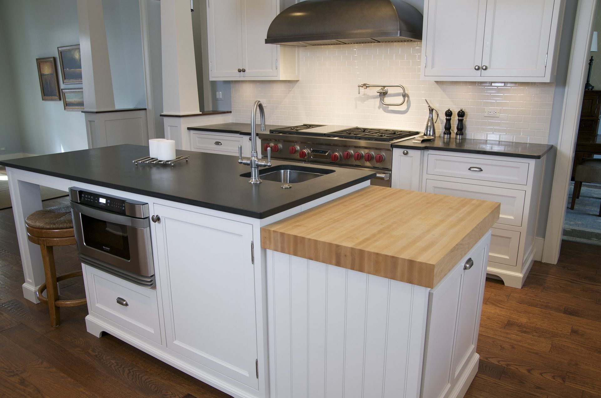 A kitchen with white cabinets and black counter tops