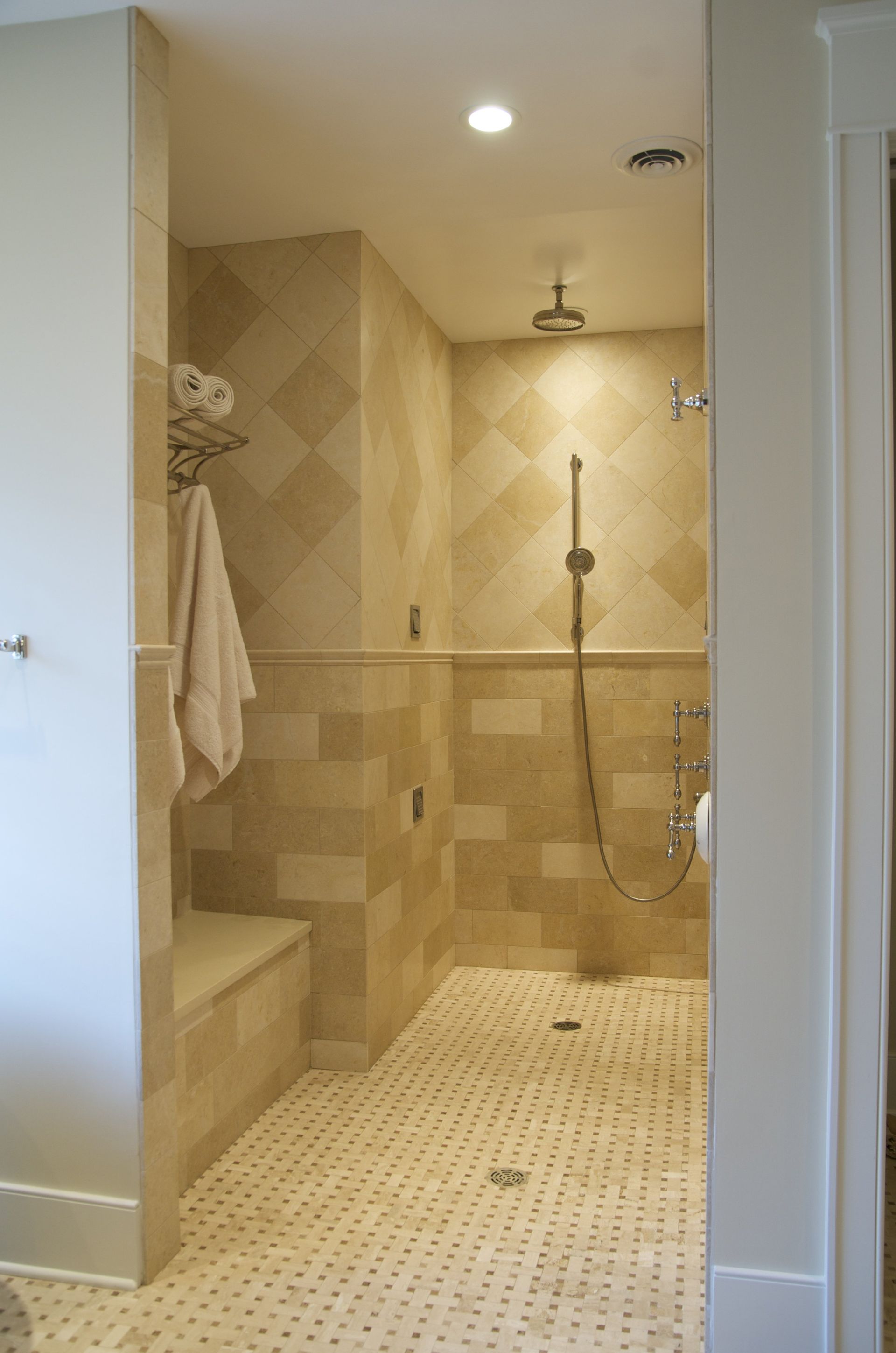 A bathroom with a walk in shower and a bench.