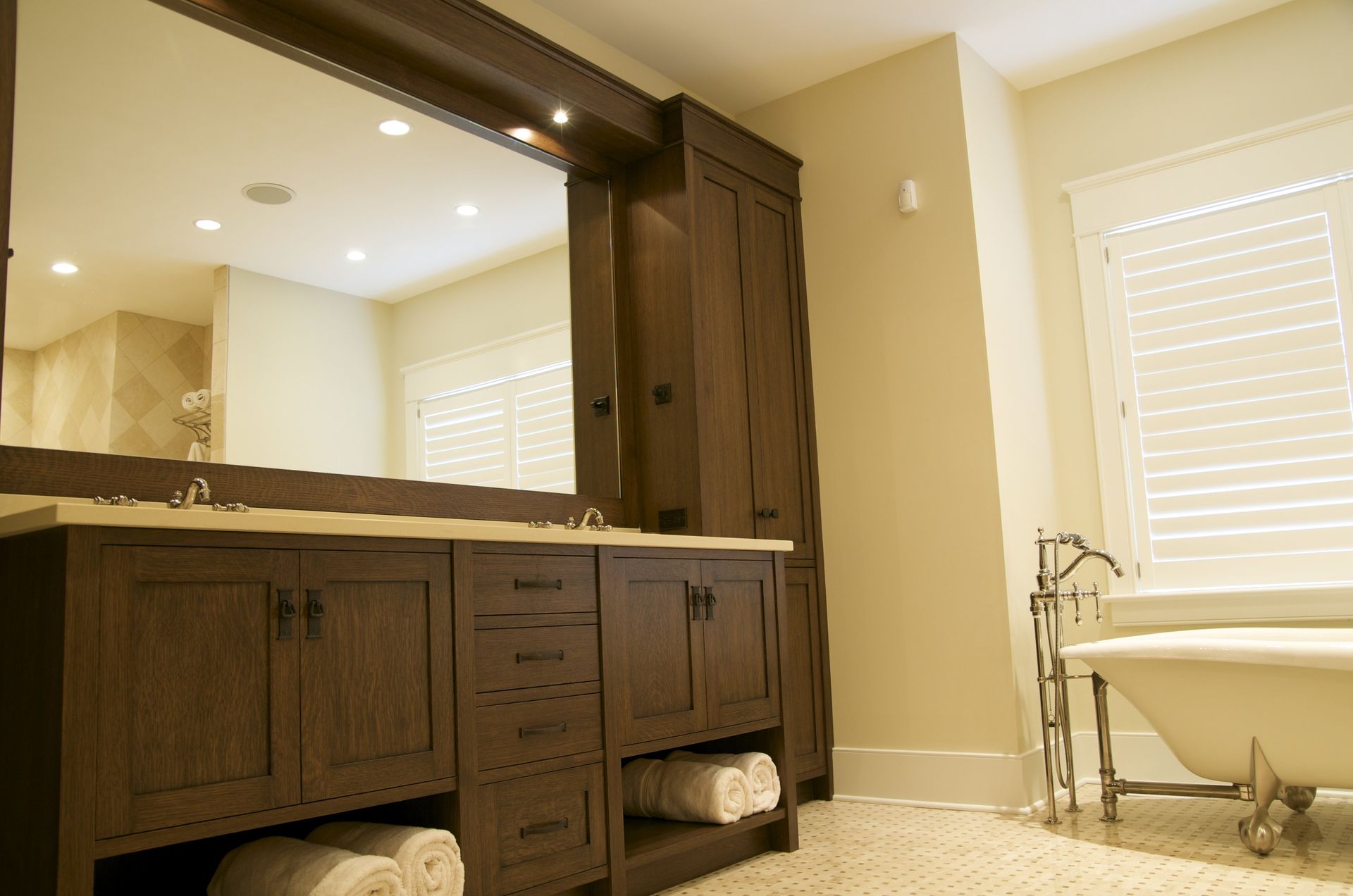 A bathroom with two sinks , a tub and a large mirror