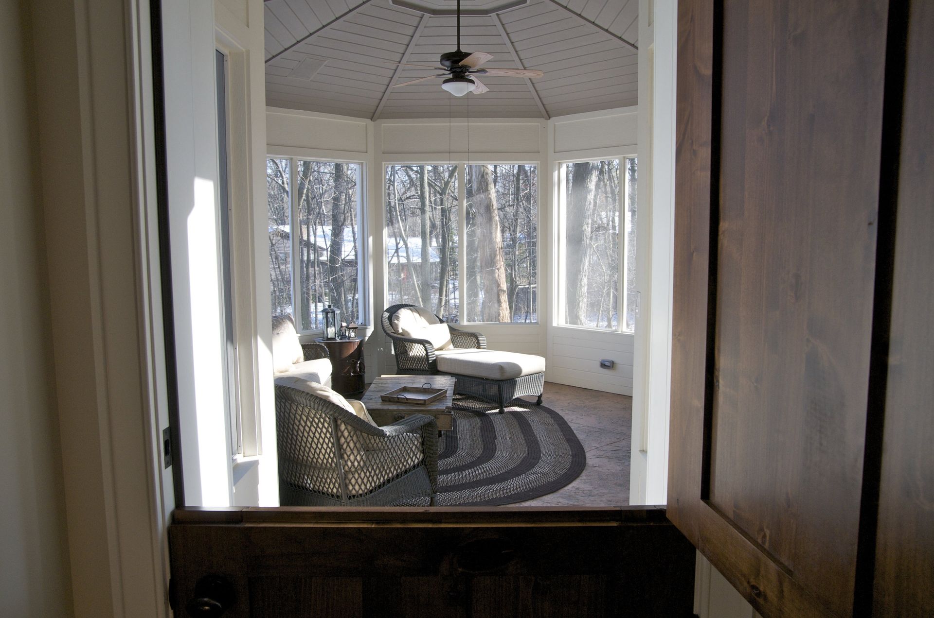 A room with a lot of windows and a ceiling fan