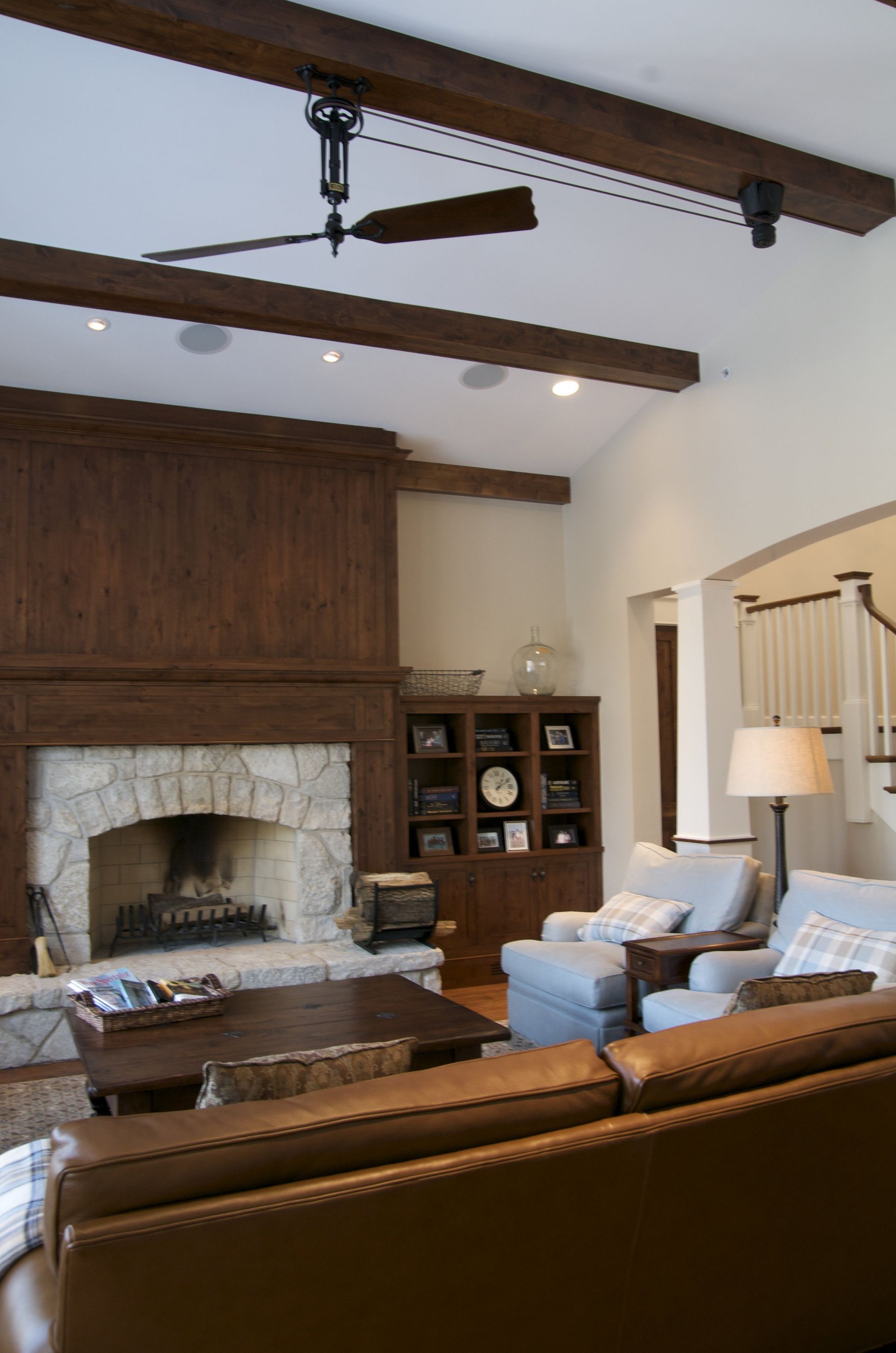 A living room with a fireplace and a ceiling fan